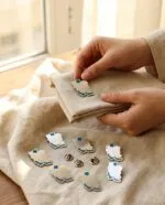 سنجاق سینه ایران روی پارچه کتان در دست مدل - نقره ۹۲۵ میناکاری آبی